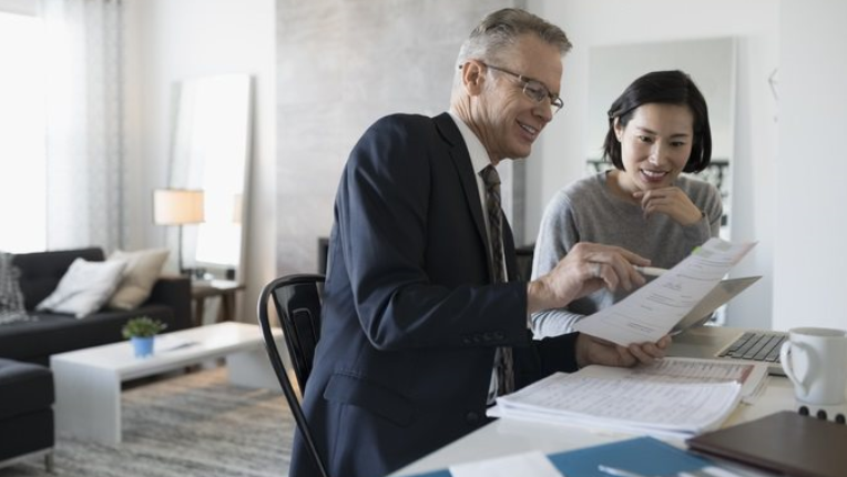 A woman looking at papers with her advisor
